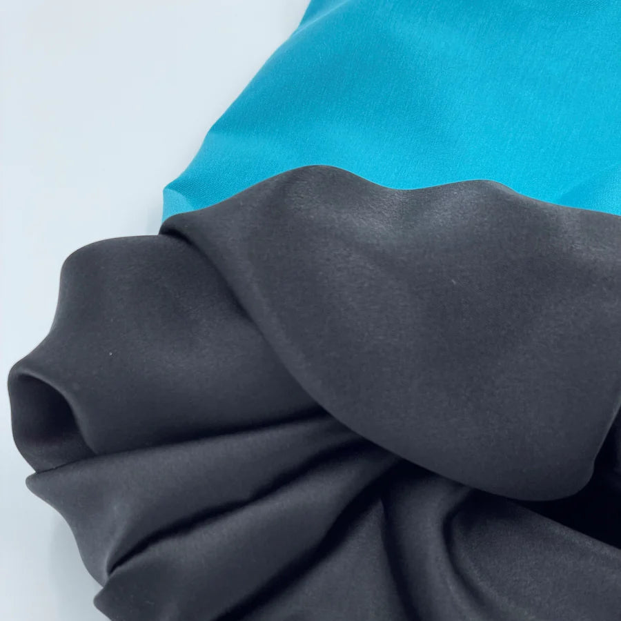 Close up of Silk Lined Tubular Hair Wrap (silk buff), blue colour with black silk lining. 