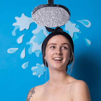 Female wearing black soft Shower Cap under a background with an art created shower. 
